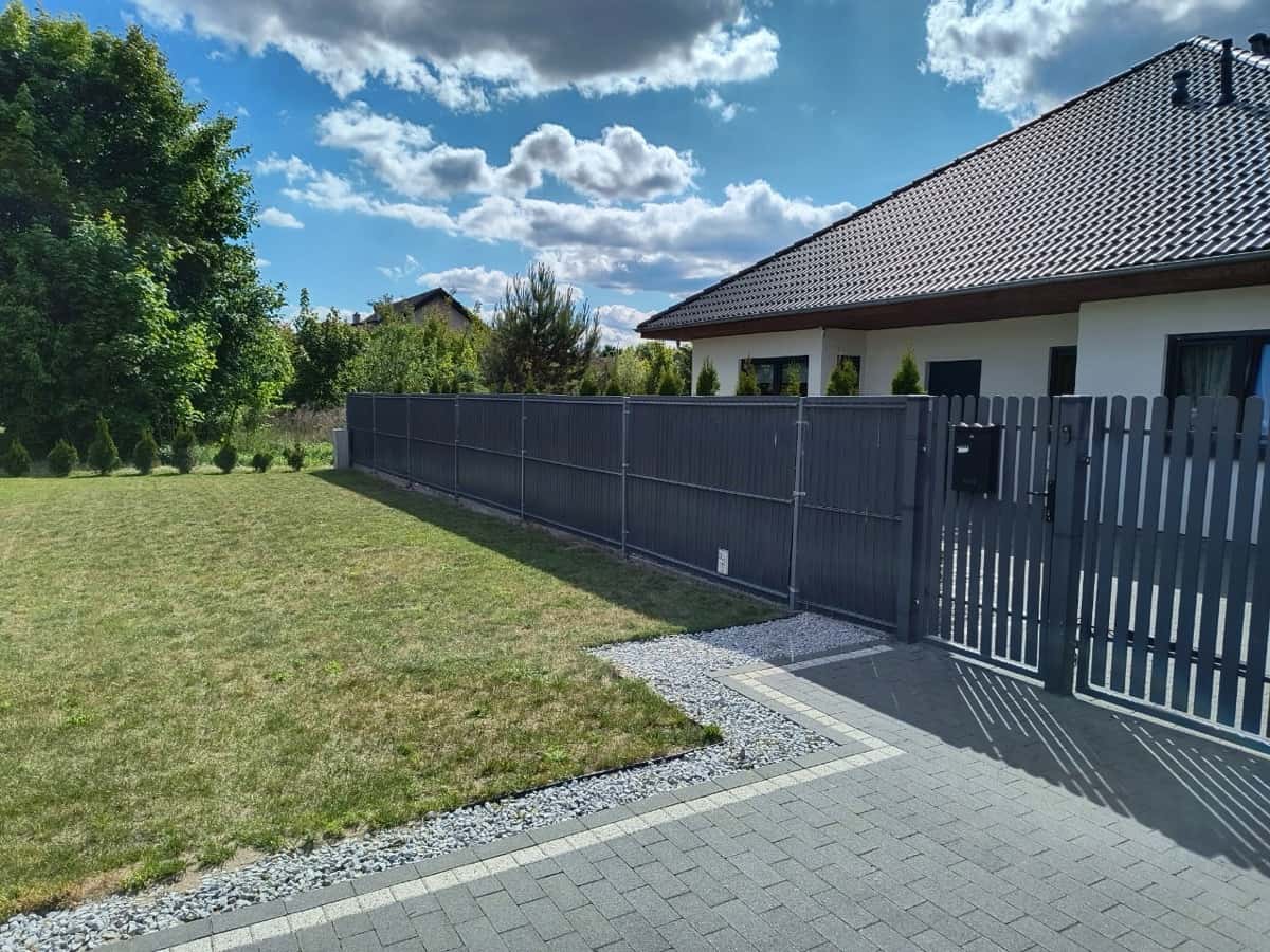 Ogrodzenie z listwami przy domu z ogrodem